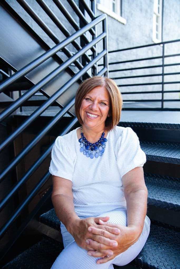 Lisa Zilli sitting on stairs in office building