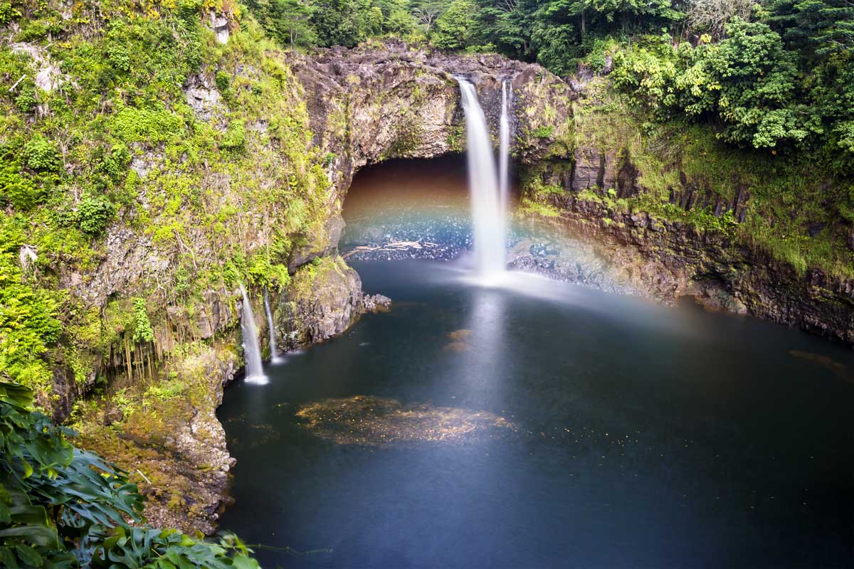 Rainbow into pool of water in Hawaii